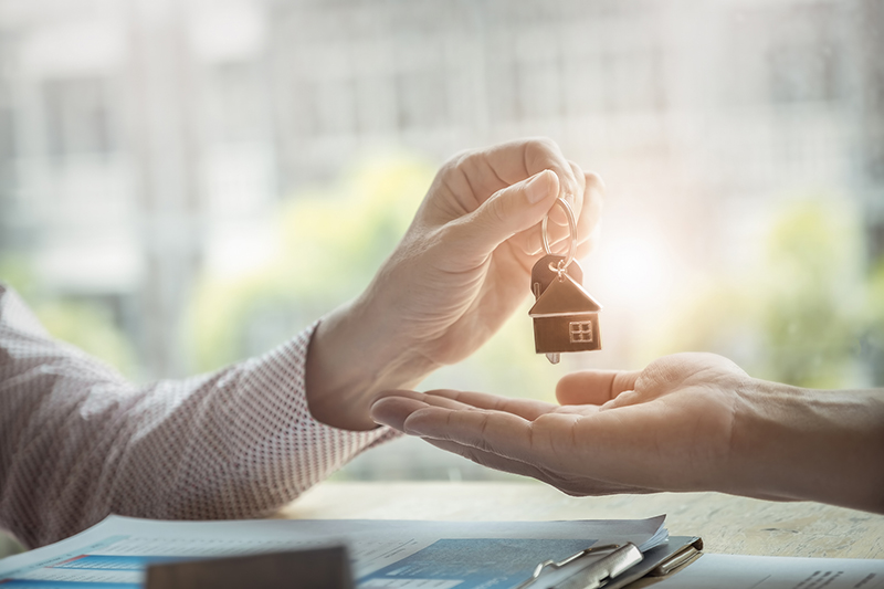 Real estate agents agree to buy a home and give keys to clients at their agency's offices. agreement and contract concept.