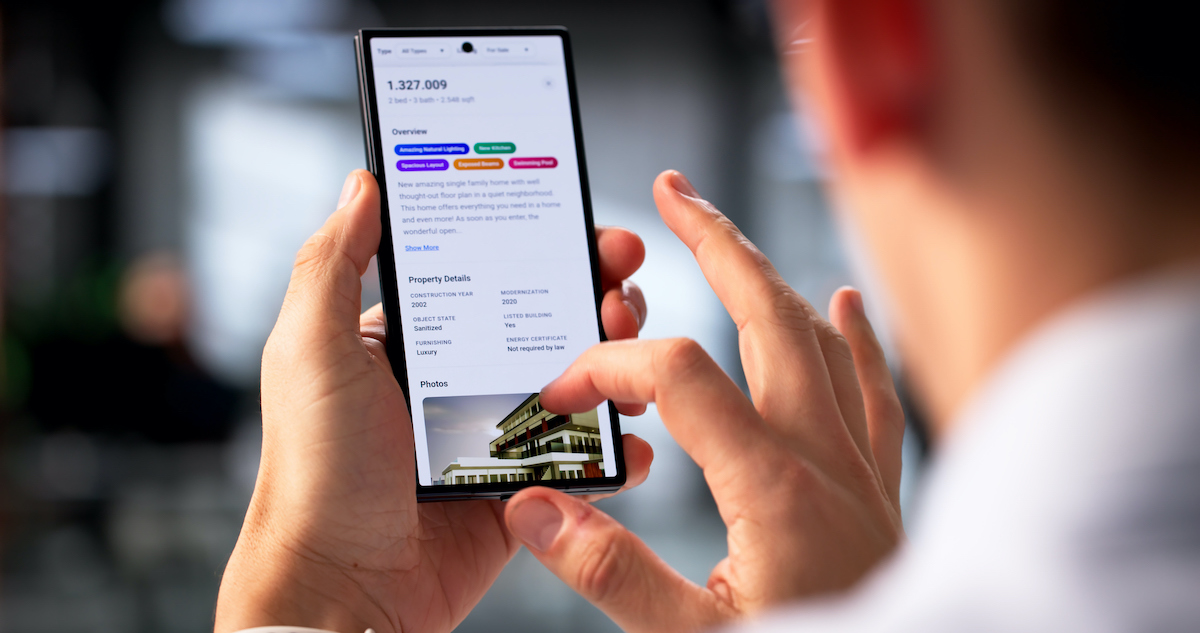 Young Latino Man Searching For Real Estate Listings On Smartphone App.